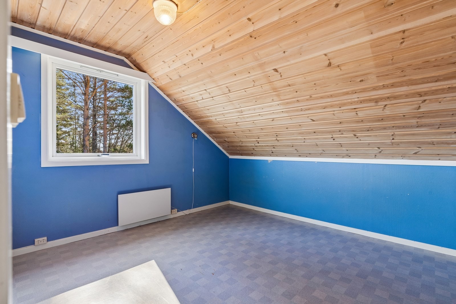 Soverom i andre etasje med skråtak og trepanel i himling. Arealet under skråtaket er ikke medregnet i bruksarealet. Galleribilde