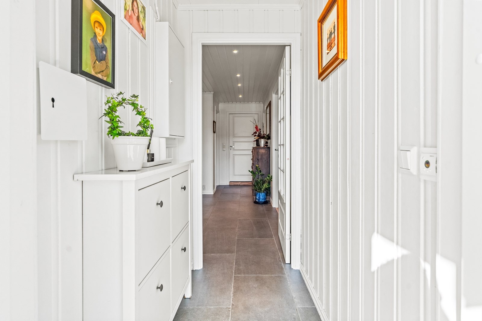 Gulvet består av store, grå fliser, og gangen har downlights i taket og plass til å henge fra seg yttertøyet. Galleribilde