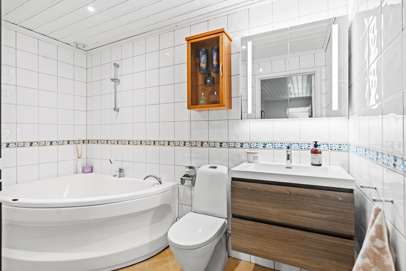 Badet i underetasjen er helfliset, utstyrt med toalett, hjørnebadekar og opplegg for vaskmaskin. Galleribilde
