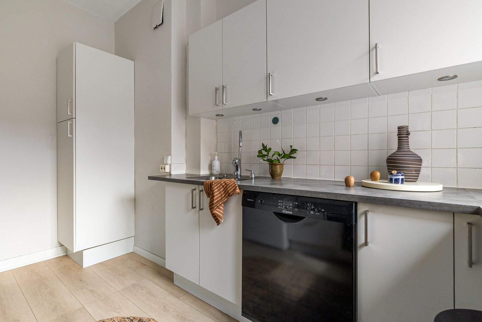 Det er opplegg for vaskemaskin på kjøkkenet ved høyskapet for tørrvarer. Galleribilde