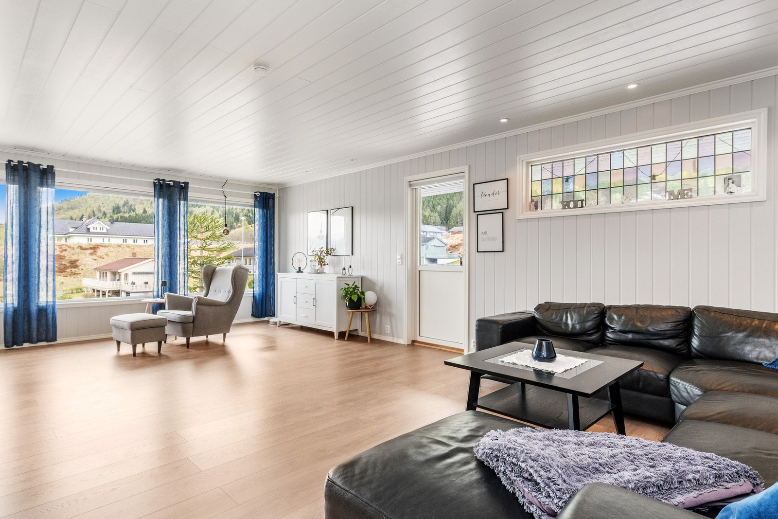 Stuen har store vindusflater som slipper inn godt med naturlig lys Galleribilde