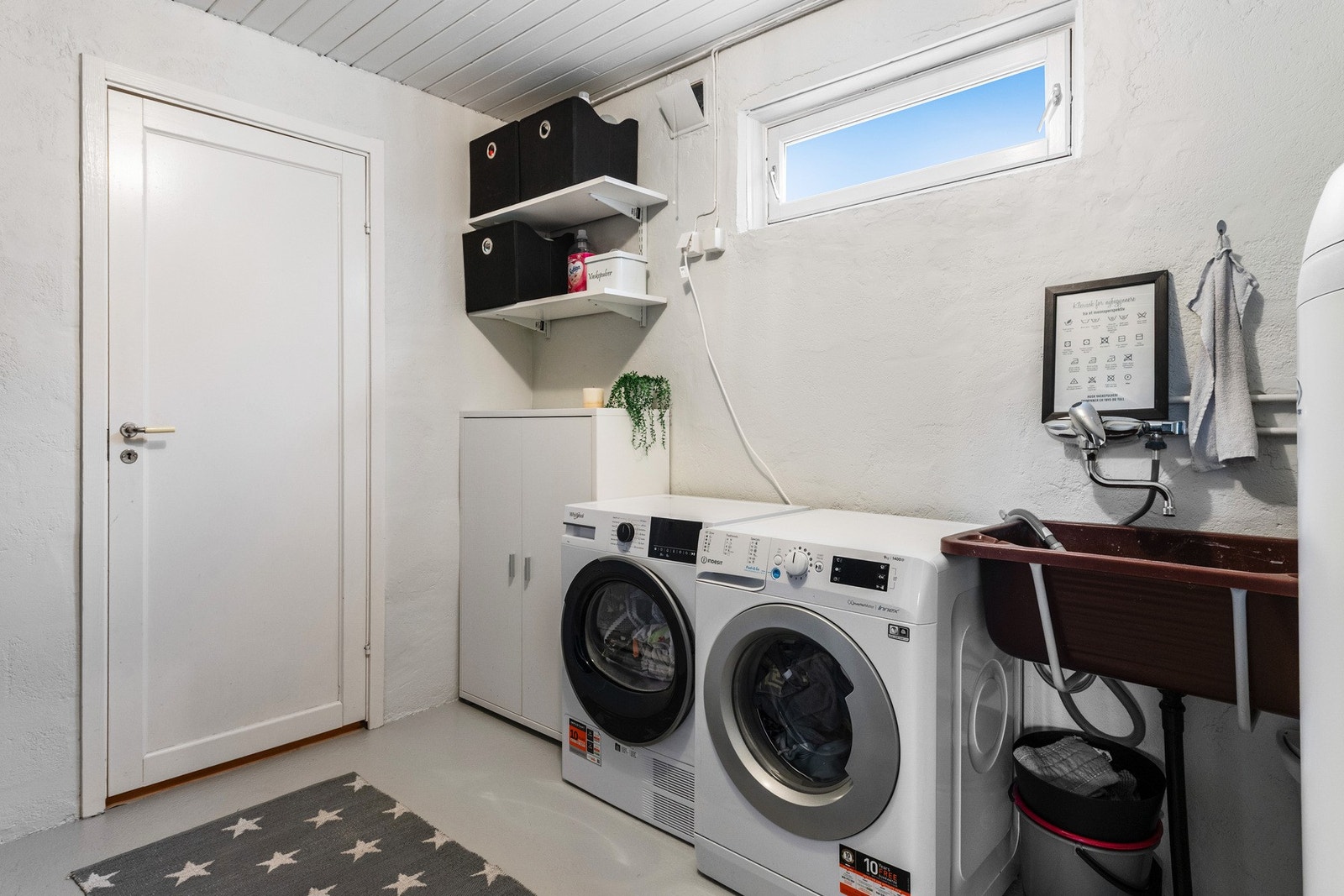 Vaskerom som er utstyrt med utslagsvask, opplegg for vaskemaskin, og dusjhjørne Galleribilde