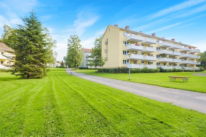 Store fellesarealer mellom og rundt bebyggelse med grøntanlegg, prydbusker og trær. Galleribilde