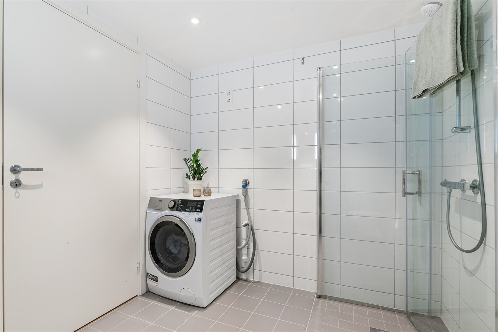 Badet er godt utstyrt med vegghengt toalett, servant og dusjnisje. I tillegg er det er praktisk oppbevaringsplass under servanten og opplegg for vaskemaskin. Galleribilde