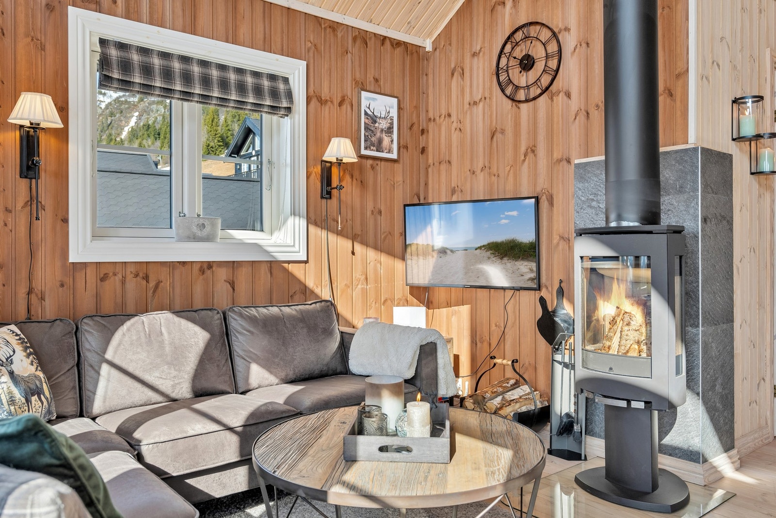 Frittstående peisovn i stue med stålpipe sørger for god stemning og lun varme også på kjølligere dager. Galleribilde
