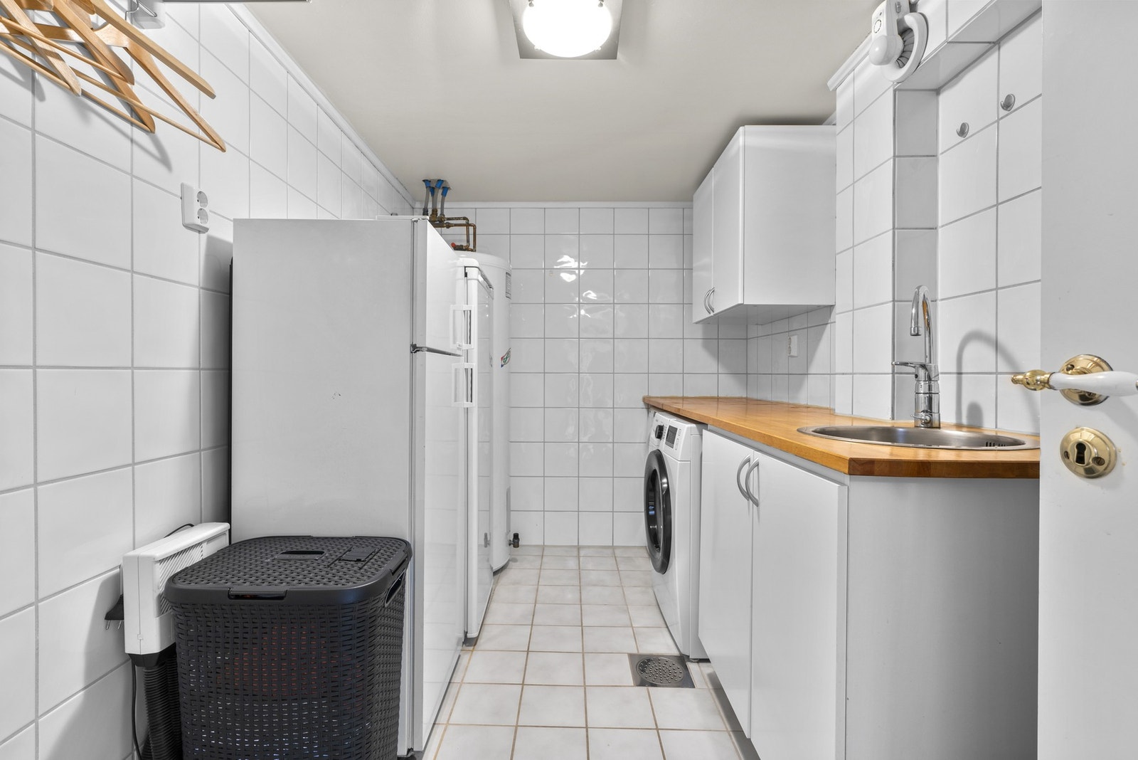 I kjelleren finner du et svært praktisk eget vaskerom. Vaskerommet er helfliset, og under benken er det opplegg for vaskemaskin og plass til tørketrommel. Galleribilde