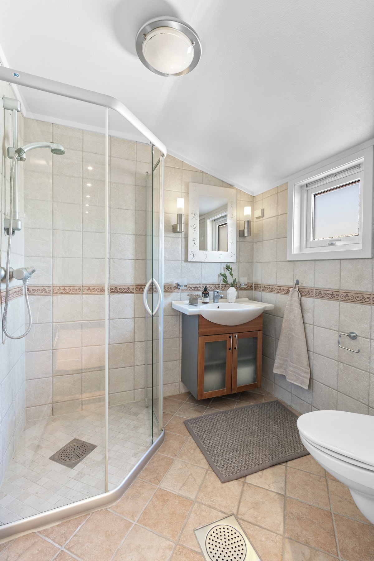 Boligen har en praktisk løsning med bad i både 1. og 2. etasje, samt et vaskerom i kjelleretasjen. På badet i 1. etg. er det varmekabler, vegghengt toalett og et dusjhjørne med skyvedør av glass. Galleribilde