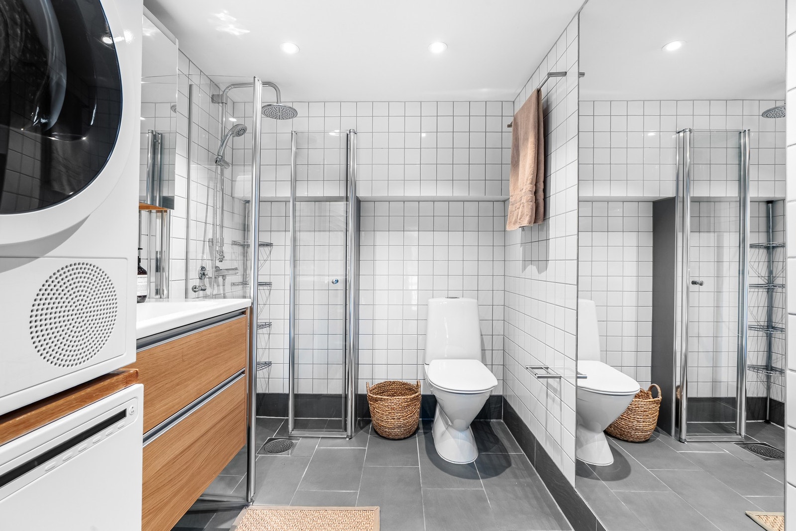 Badet på hovedplanet er innredet med grå gulvfliser og hvite veggfliser. Galleribilde