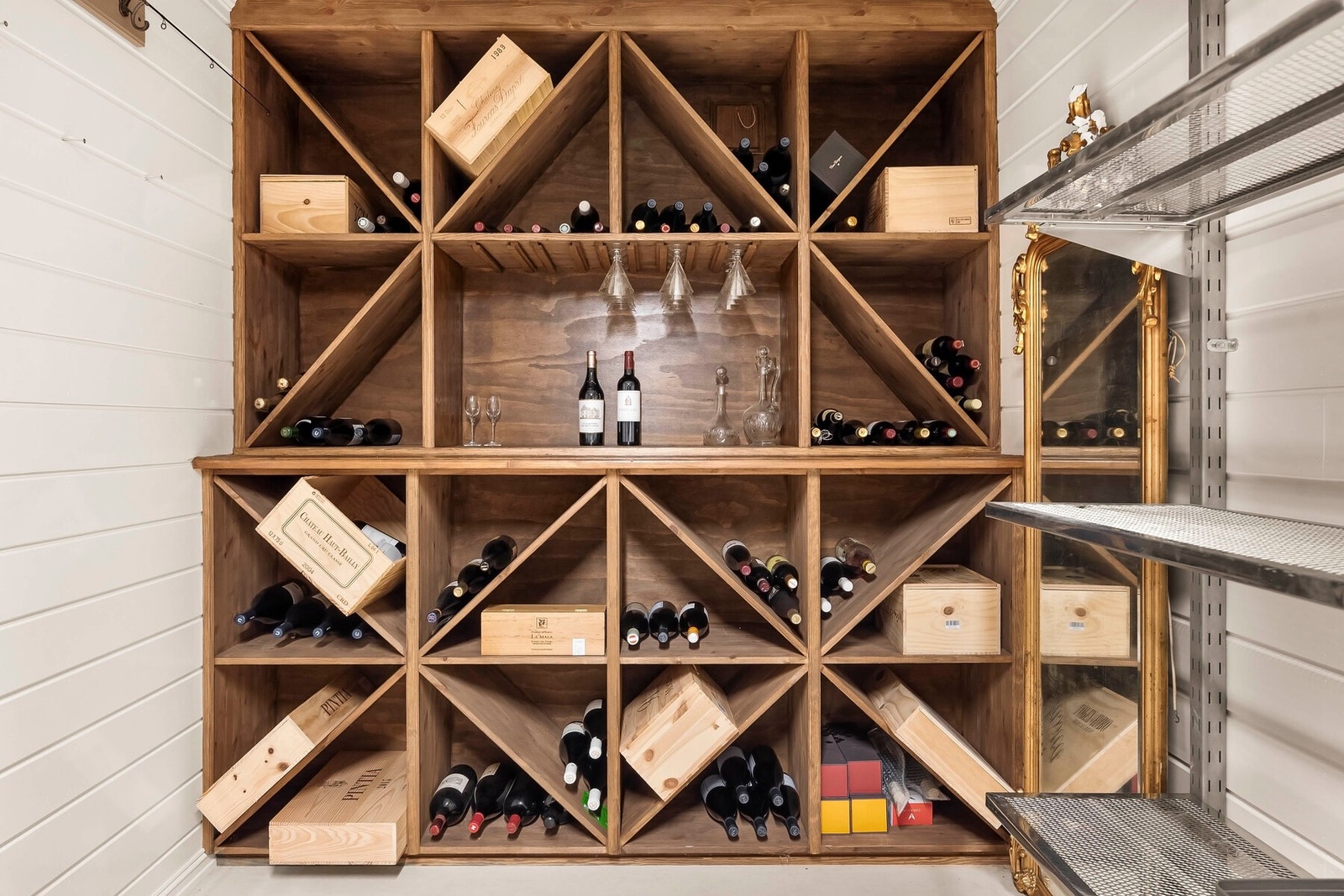 En nesten 16 kvm stor bod med plass til oppbevaring av utstyr og annet som ikke er i daglig bruk. En vegg har plassbygde hyller for oppbevaring av vin. Galleribilde
