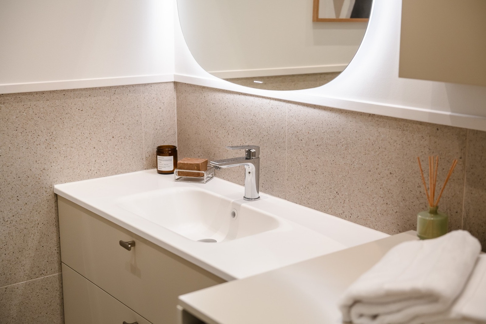 Badet er innbydende og stilrent, og ble modernisert i 2025, med fliser, downlights og heldekkende servant med skap. Galleribilde