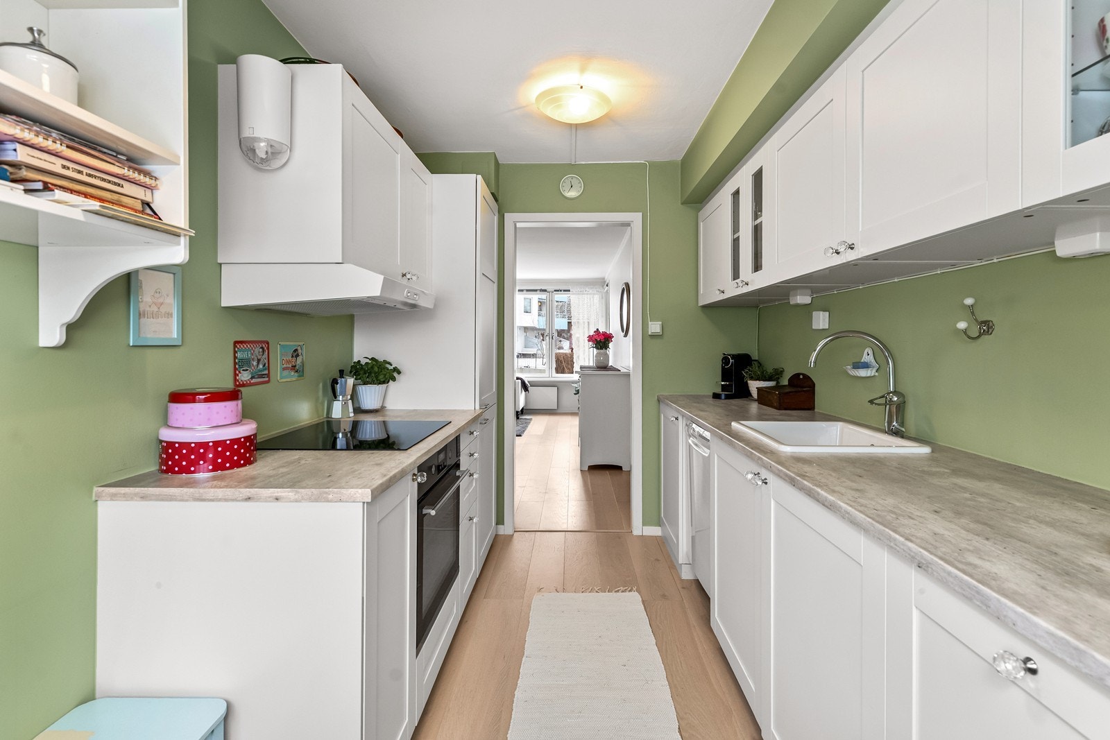 Kjøkkeninnredningen er en klassisk IKEA innredning fra 2020 med hvite, profilerte fronter, laminat benkeplate og vitrineskap. Galleribilde