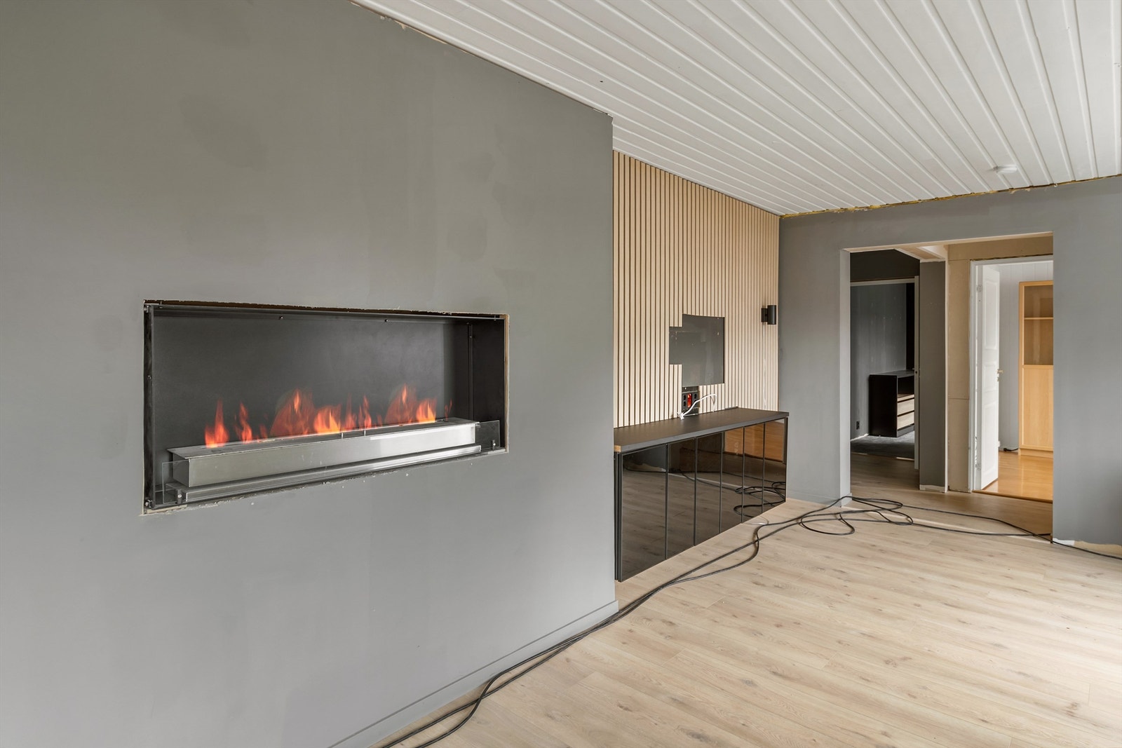 Spileplater på deler av veggen gir en moderne og stilren detalj. Peisen er per i dag ikke tilkoblet, og funksjonen er derfor ikke verifisert. Galleribilde