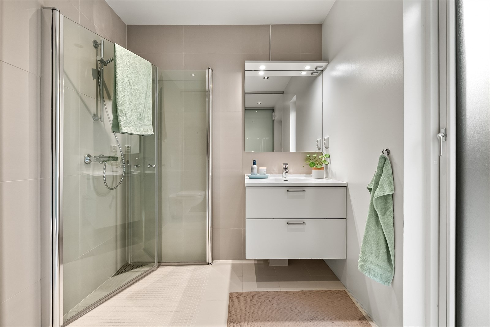 Badet har servantinnredning med underskuffer og belysning over speil. Galleribilde