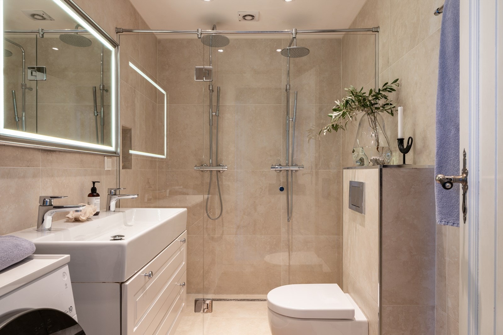 Badet er moderne og pent, renovert i 2013 og bygd etter TEK10-standard. Rommet har beige fliser på gulv og vegger, gulvvarme og downlights. Galleribilde