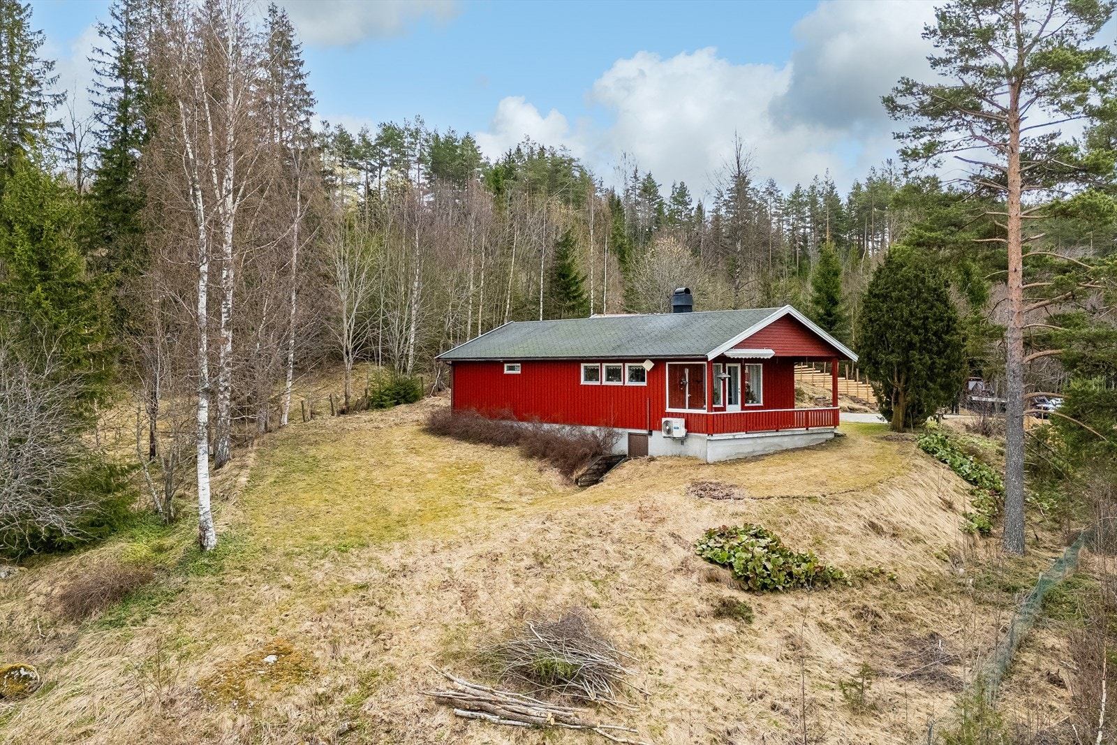 Tomten er skrånende med en kombinasjon av opparbeidet plen og naturtomt med variert beplantning. Galleribilde