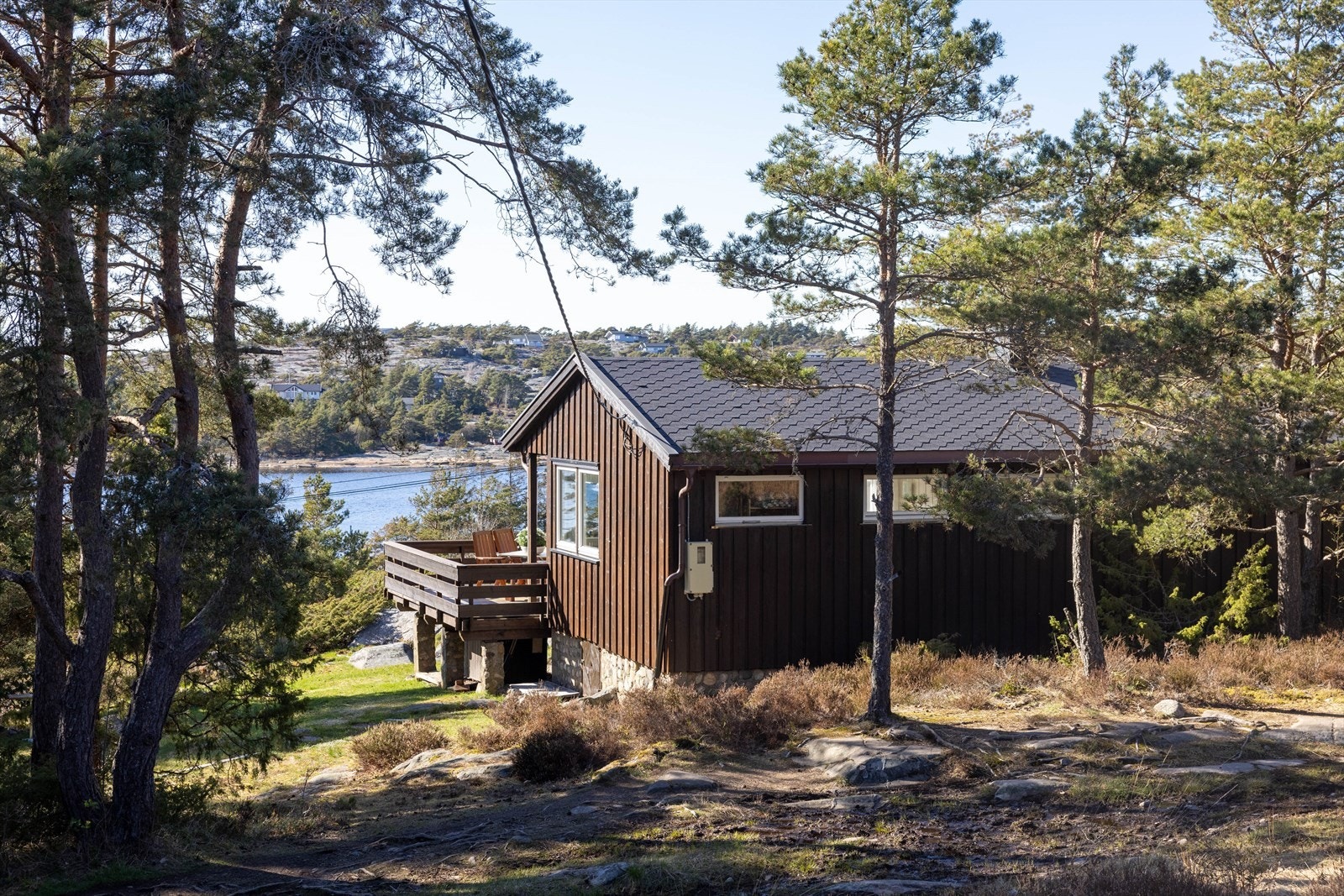 Rundt vokser bølgende gress, og mot nord rammer kystfuruene inn boligen til en lun oase, mens mot vest og sør, åpner landskapet seg vakkert ut mot sjøen. Galleribilde