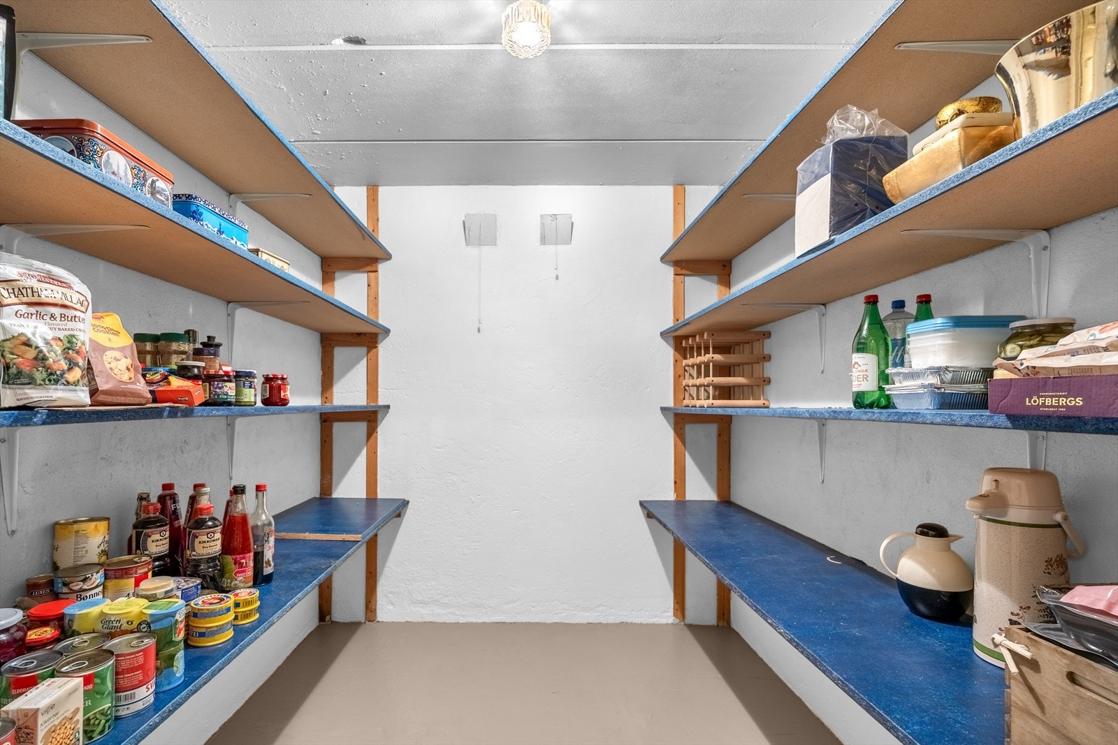 En av bodene er innredet som matbod med solide hyller. Galleribilde