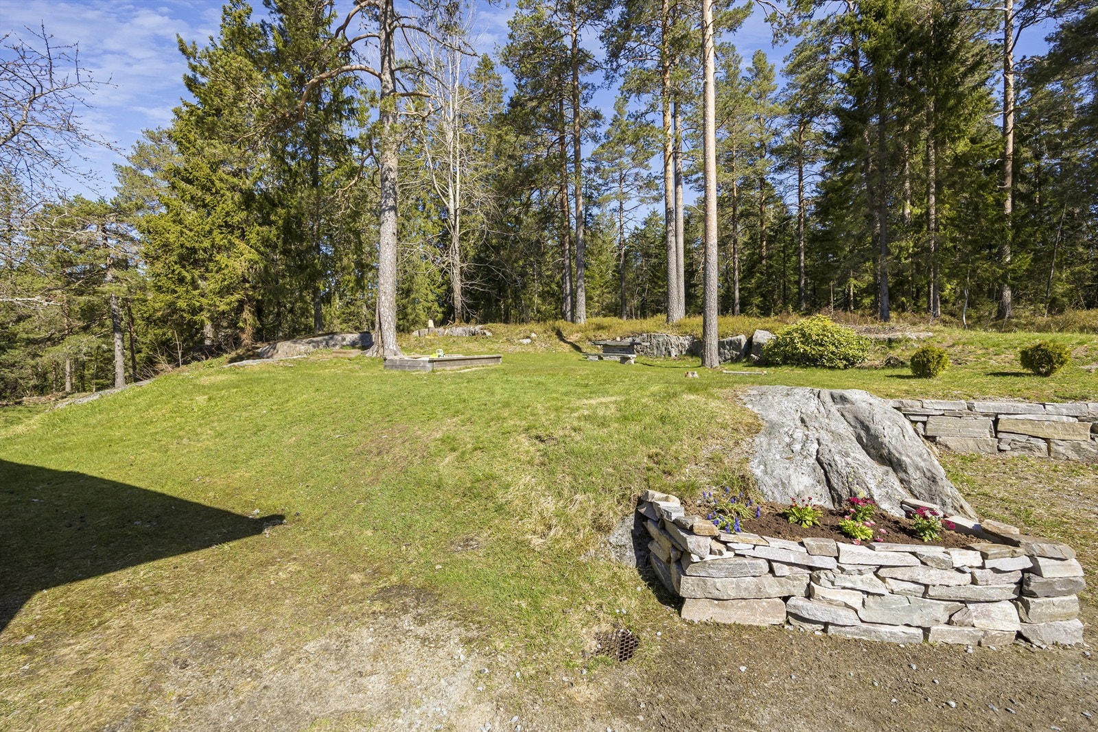 Tomten er pent opparbeidet med natursteinsmurer som skaper fine overganger i terrenget. Galleribilde