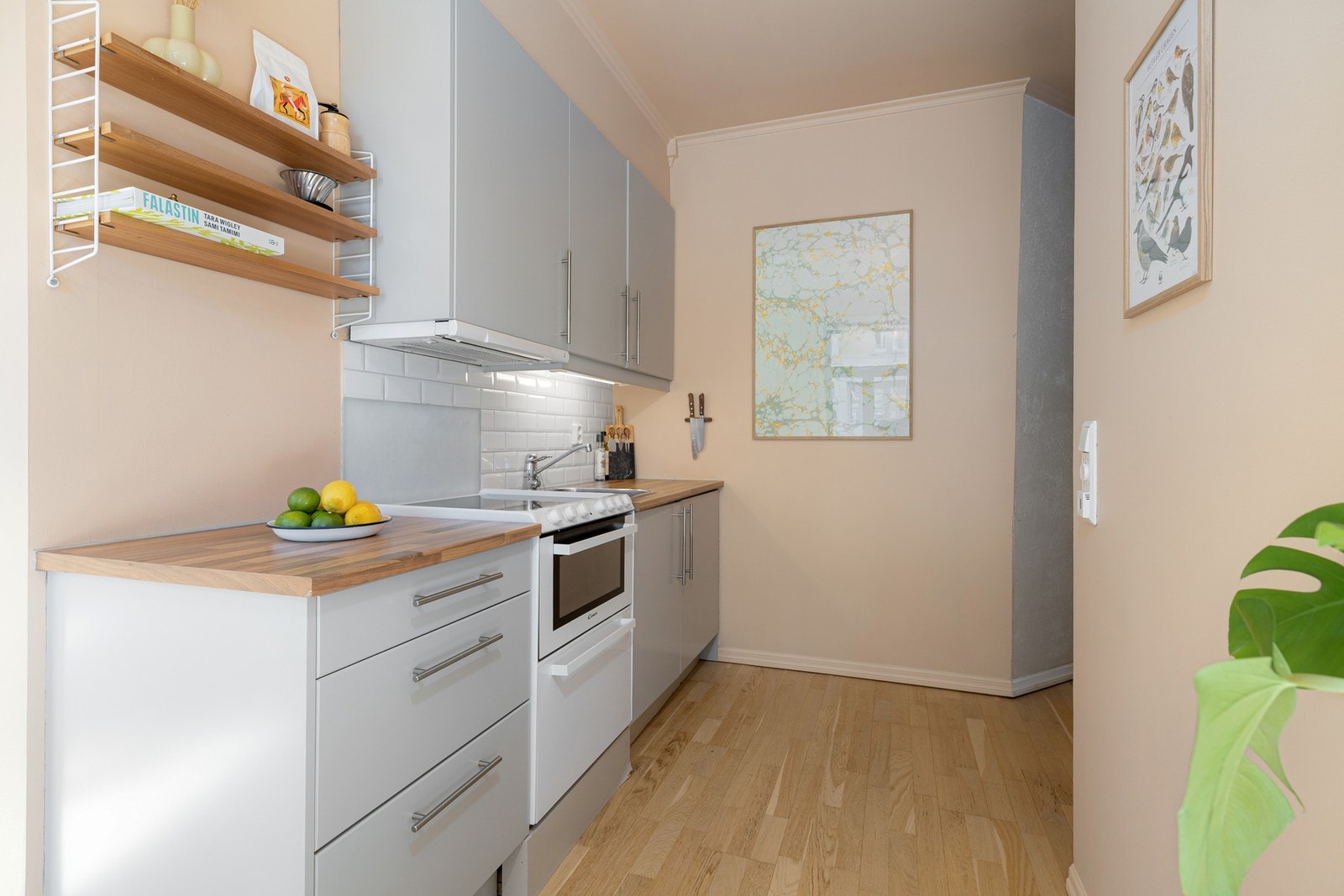 Lys og tidløs kjøkkeninnredning med glatte fronter og laminert benkeplate med nedfelt oppvaskkum. Galleribilde