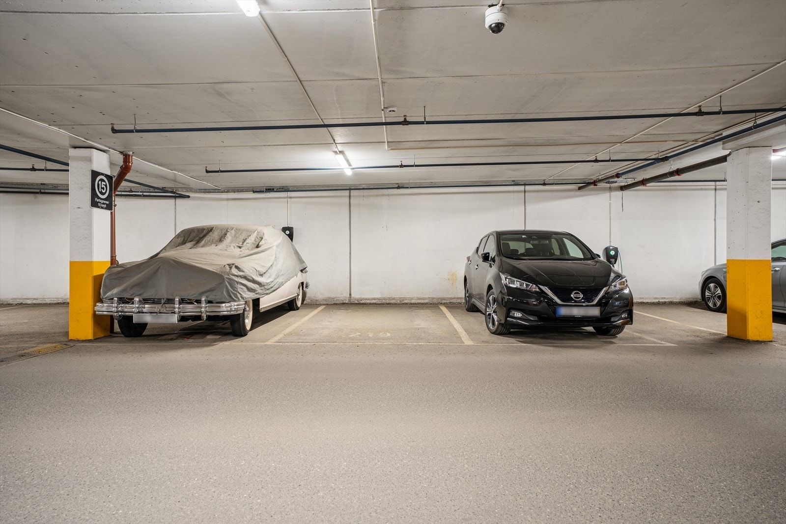 Parkering i felles garasjeanlegg med heisadkomst. Det er montert elbil-lader. Galleribilde