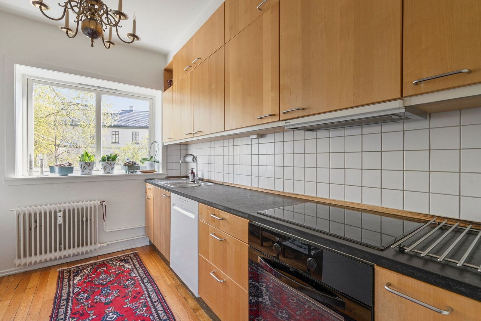 Kjøkkenet fremstår som pent. Her får du en innredning med stein benkeplater, flislagt backsplash og glatte fronter som gir et tidløst preg. Galleribilde