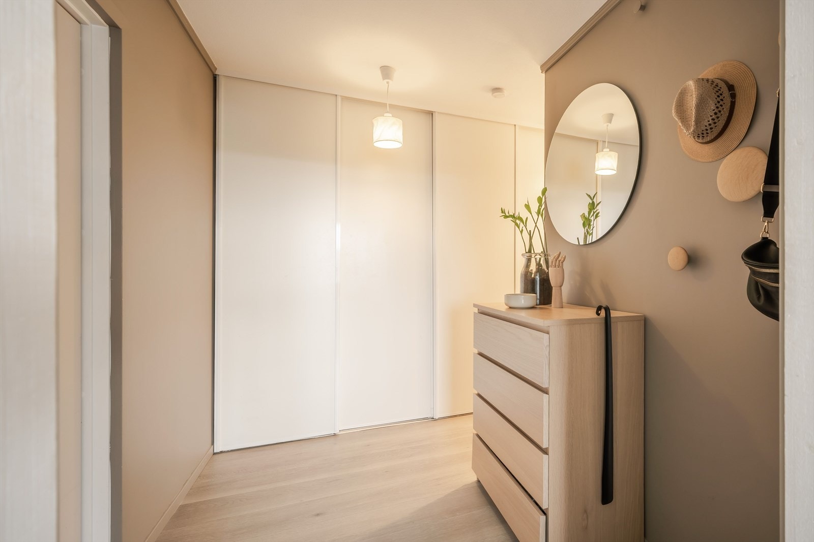 Velkommen inn. I gangen er det etablert en stor og innredet skyvedørsgarderobe som har rikelig med plass for klær og sko. Galleribilde