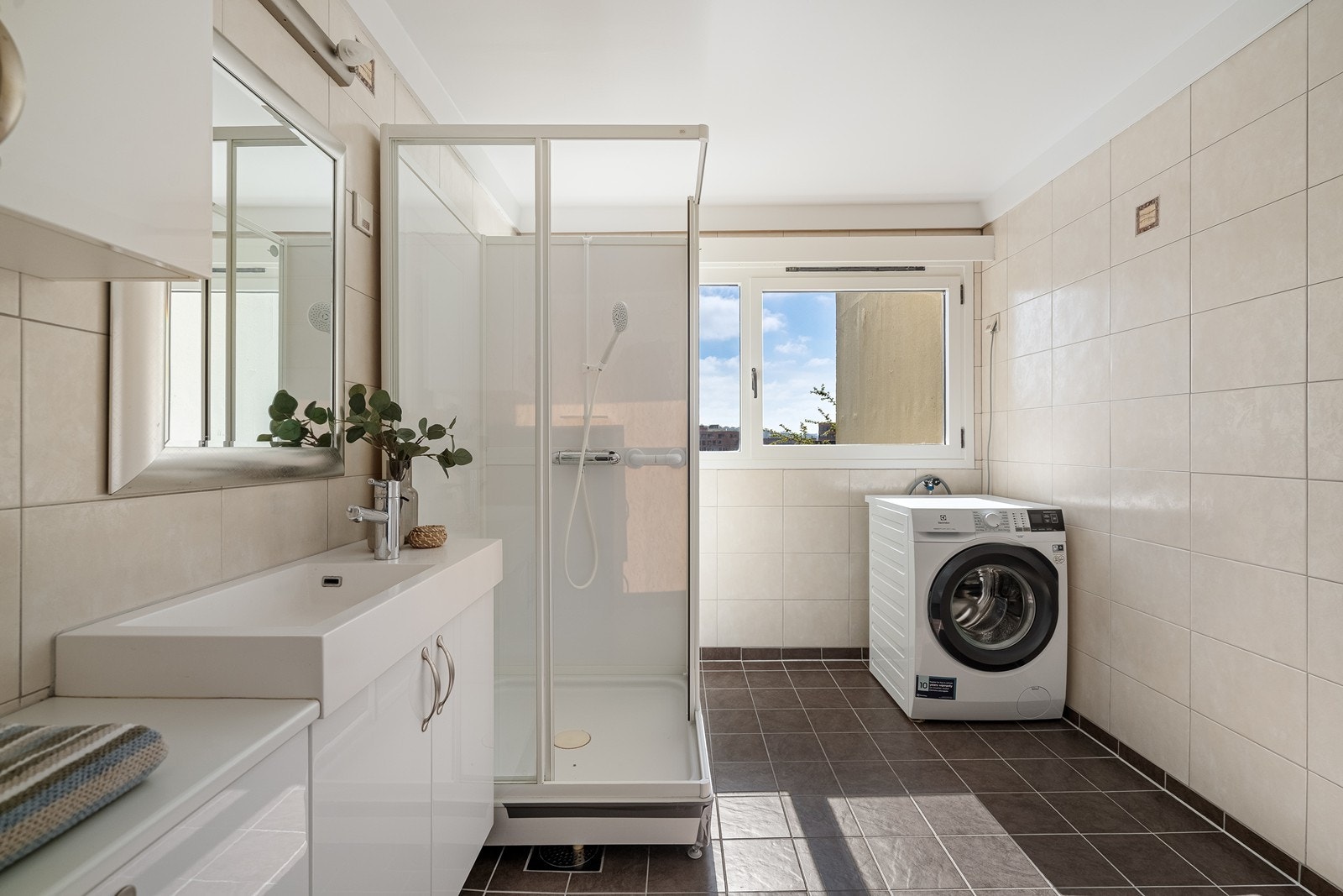 Badet inneholder innredning med heldekkende servant, toalett, dusjkabinett samt plass til vaskemaskin. Galleribilde