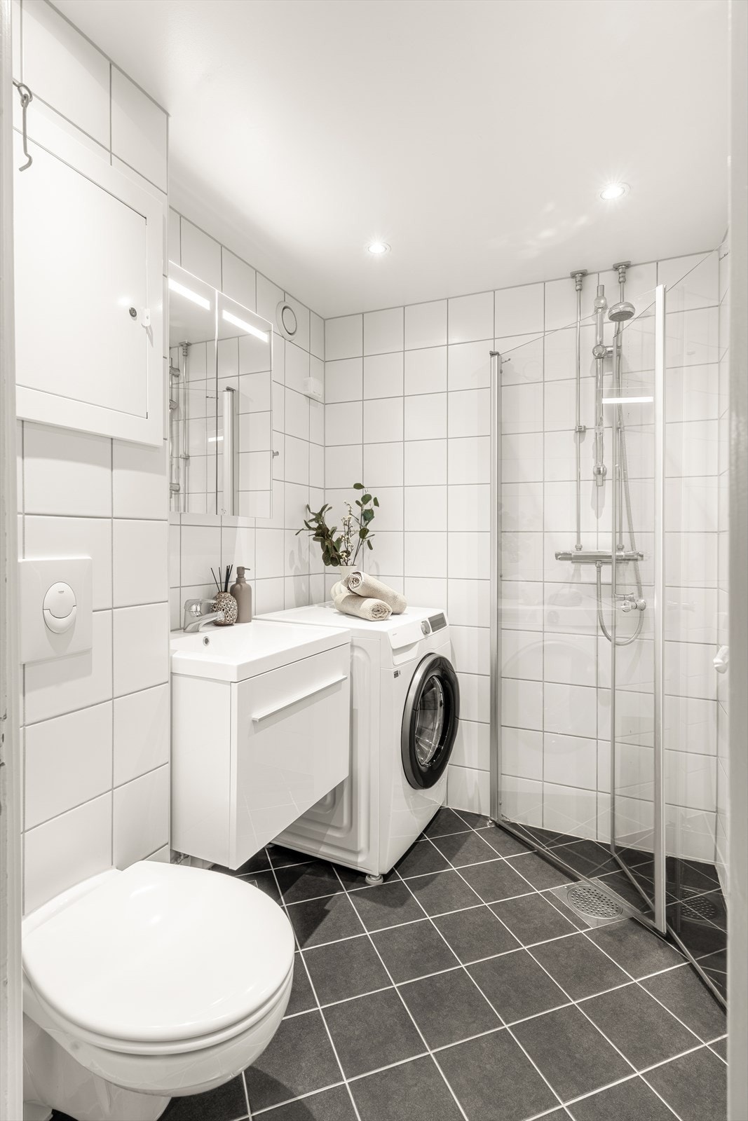 Lyst og pent baderom med flislagte overflater og underliggende gulvvarme. Opplegg og plass til vaskemaskin. Galleribilde