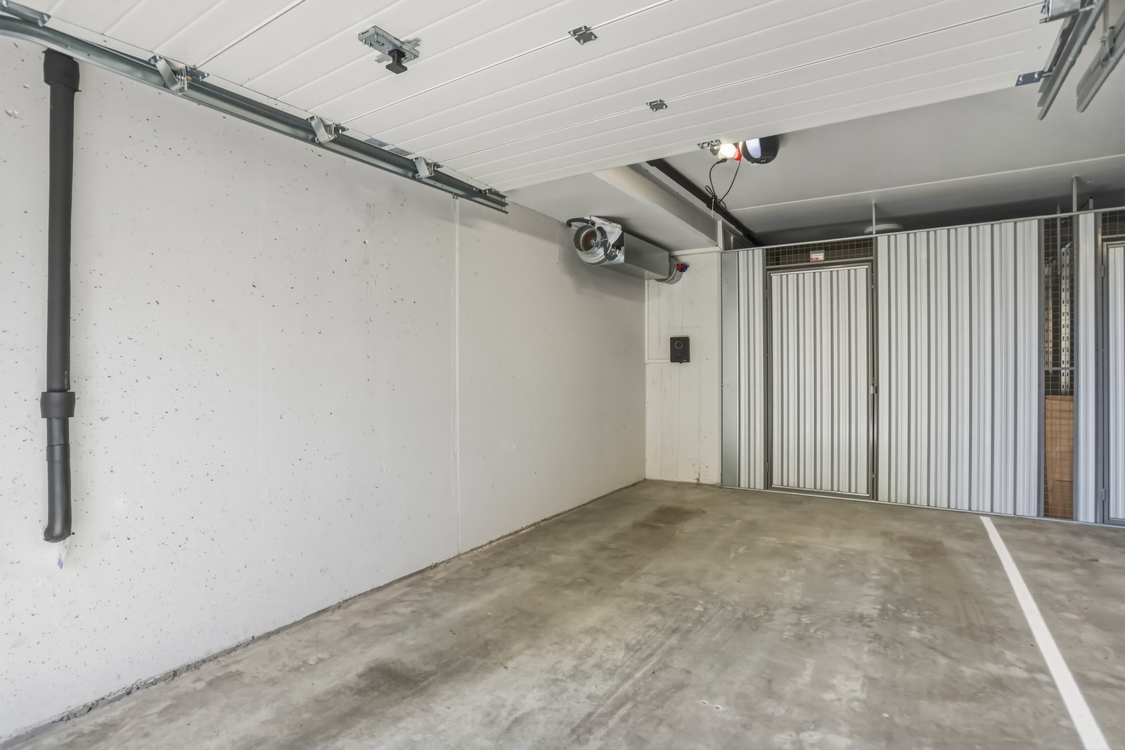 Garasjeplass med elbil lader og lagringsbod på innsiden. Galleribilde