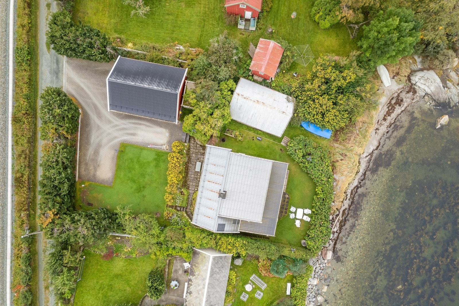 Dronebilde av eiendommen. Eiendommen har en svært unik beliggenhet, bokstavelig talt et steinkast fra fjorden. Galleribilde