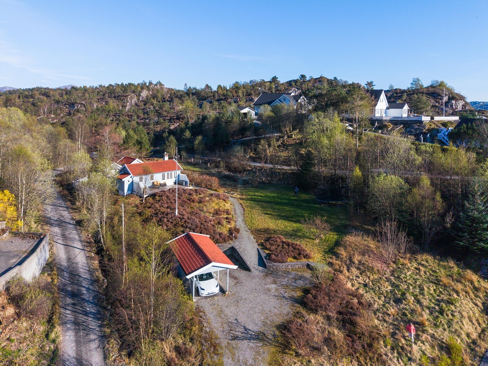 Det er gode parkeringsmuligheter på tomten med både carport, parkeringsplass på grus og parkeringsplass bak anneksene. Galleribilde