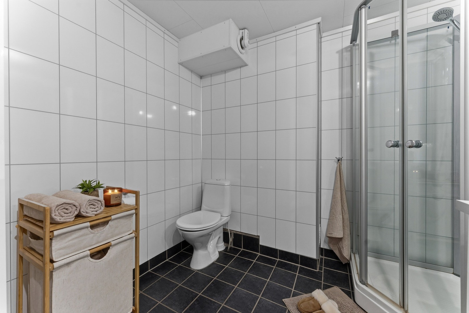 Badet har plater på vegg og vifte ut. Galleribilde