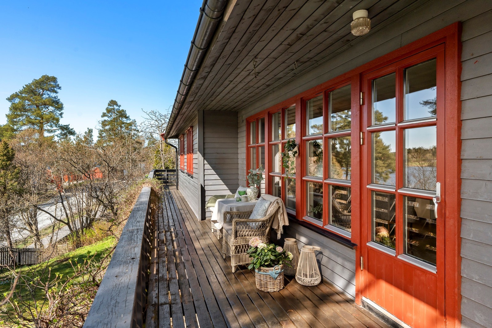 Romslig veranda med plass for sittegrupper, solsenger og grill. Galleribilde