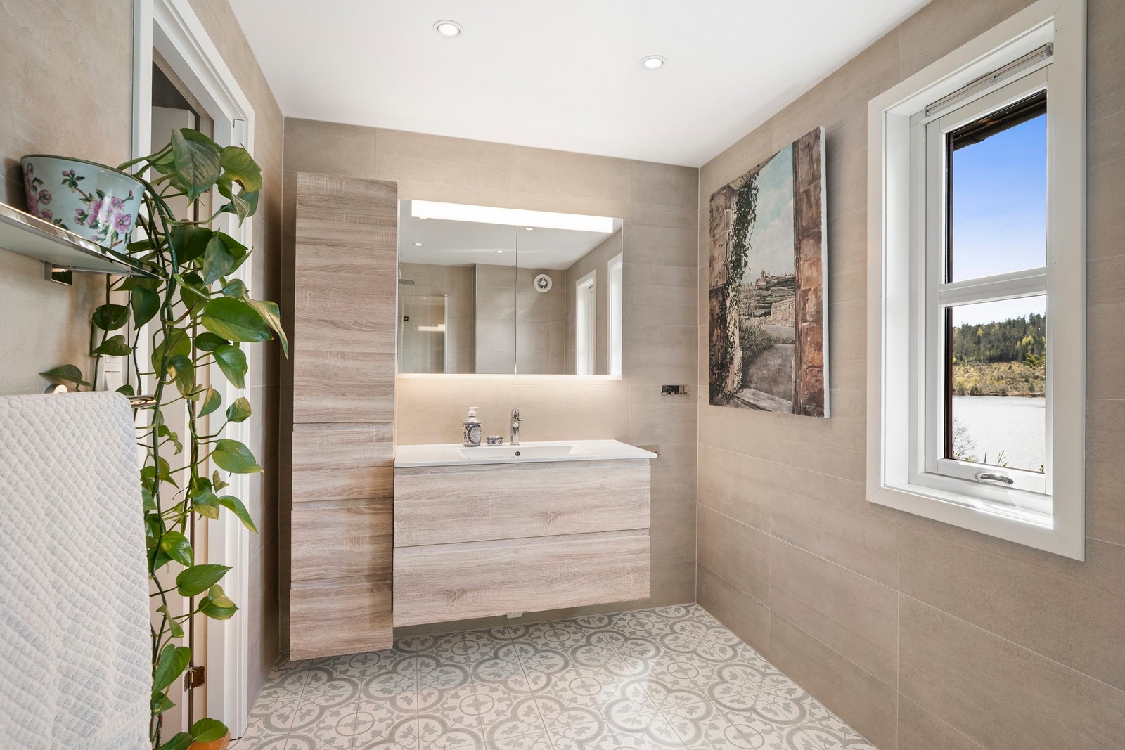 Badet er moderne og ble pusset opp i 2020. Rommet innredet med nedfelt servant, veggmontert toalett og dusjvegger/hjørne. Galleribilde