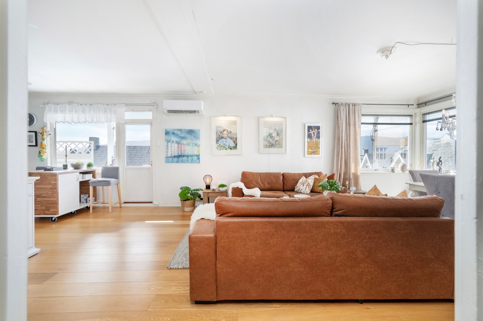 Her får du en romslig og åpen stue/kjøkken-løsning med store vindusflater. Galleribilde
