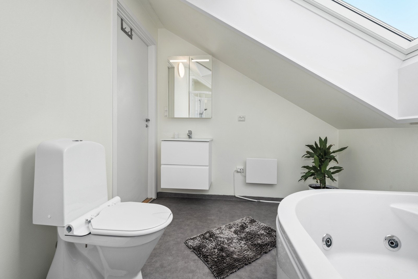 Badet har malte flater på vegg og gulv med laminat og behagelig gulvvarme. Galleribilde