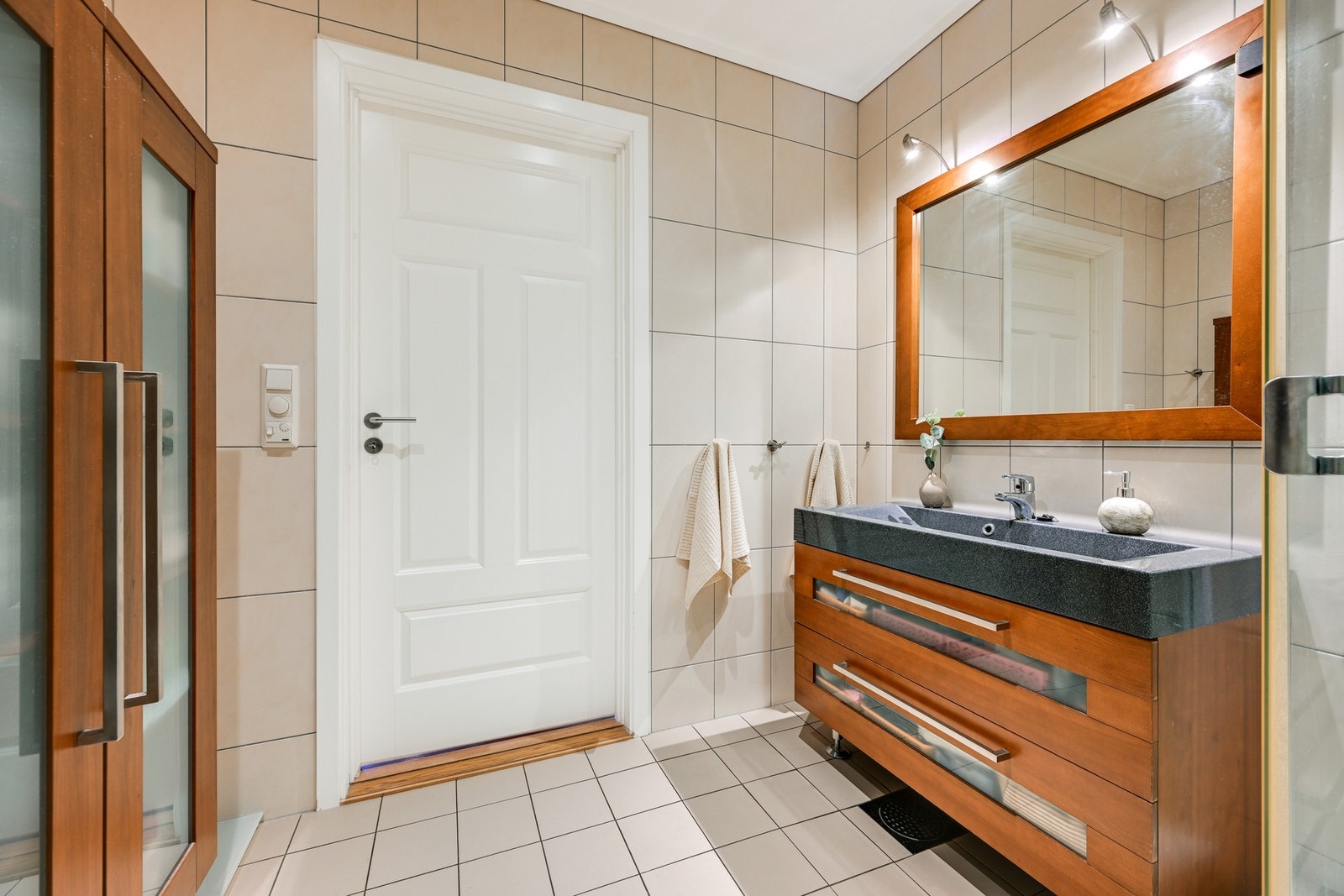 Badet er innredet med dusjkabinett, pen baderomsinnredning, skap og klosett. Galleribilde