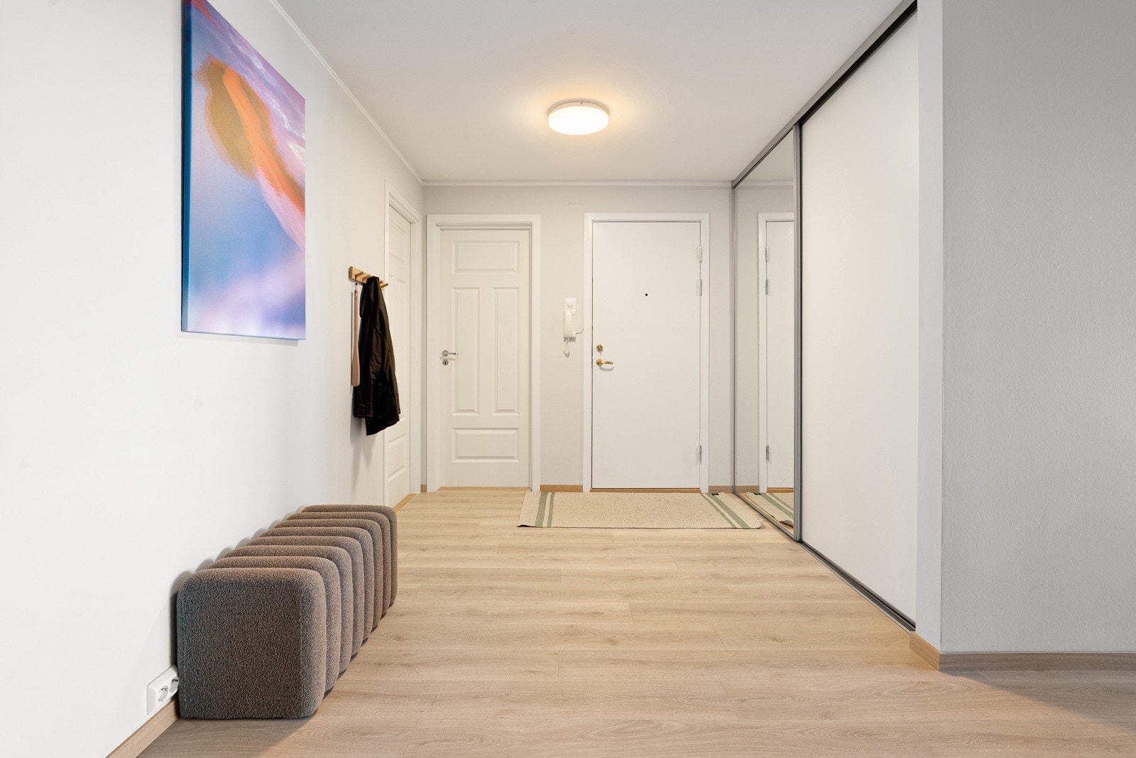 Stor og innbydende entrè med romslig skyvedørsgarderobe. Galleribilde