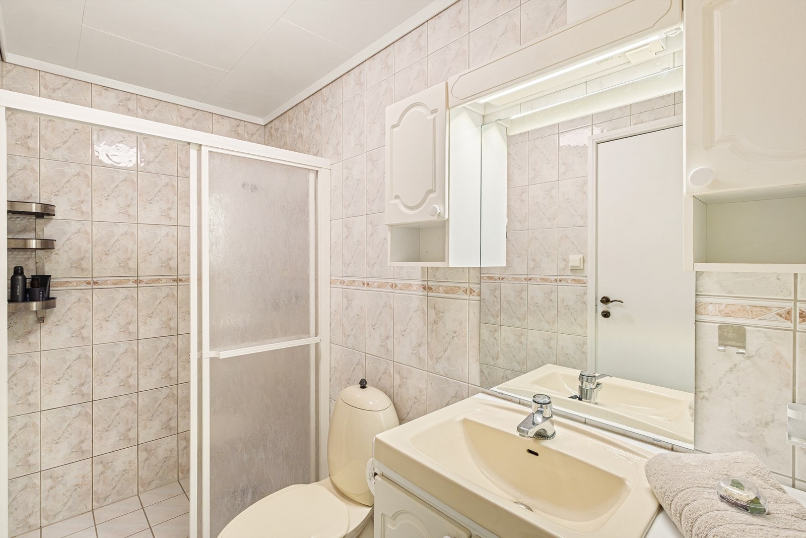 Badet i 1. etg er helfliset og har dusjkabinett. Badet er fornyet i ca. 1995. Galleribilde