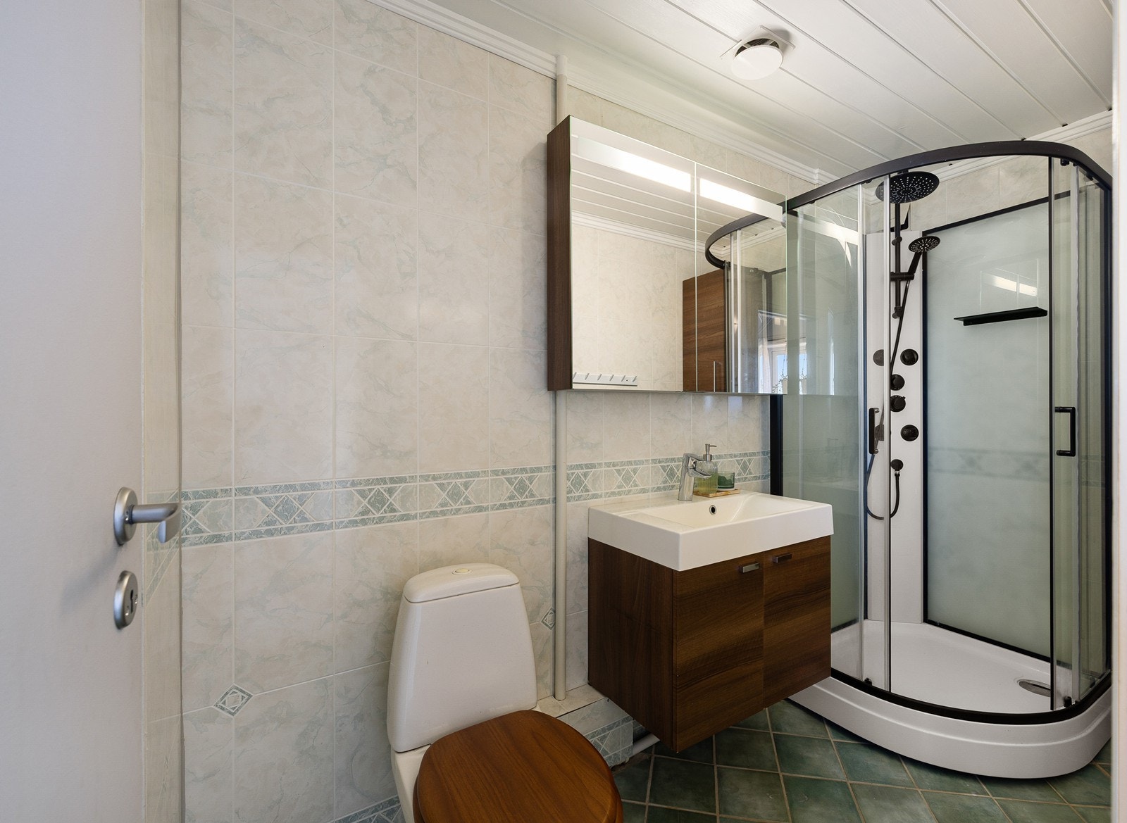 Etasjen har et bad med fliser på gulv og plater på vegger. Innredningen består av et underskap/overskap, servant, speil og ett dusjkabinett Det er også tilkoblet et vannklosett. Badet har naturlig ventilasjon. Galleribilde