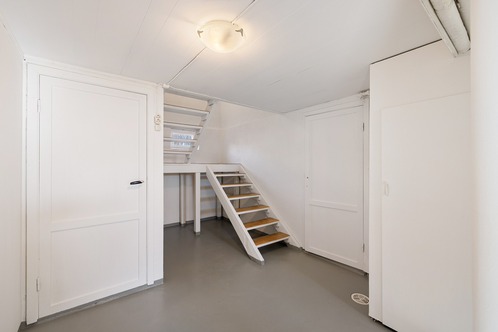 Trappen tar deg ned i en gang. Hele kjelleretasjen er regnet som bodareal, og egner seg til lagring. Galleribilde