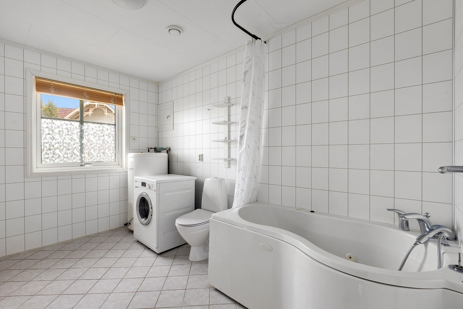 Stort bad med badekar og opplegg for vaskemaskin. Galleribilde