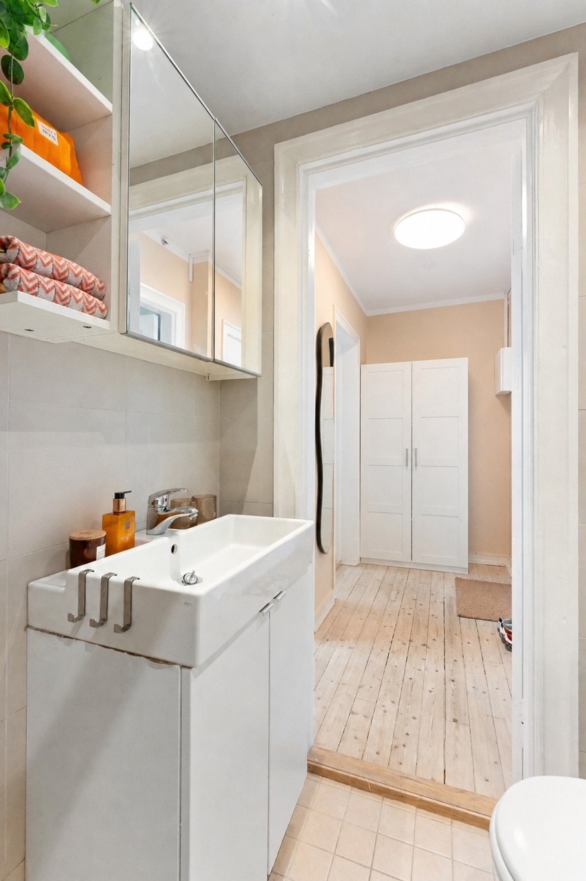 Badet er innredet med servantskap, speilskap, gulvmontert toalett, dusjhjørne og har opplegg for vaskemaskin. Det er også varmekabler her. Galleribilde