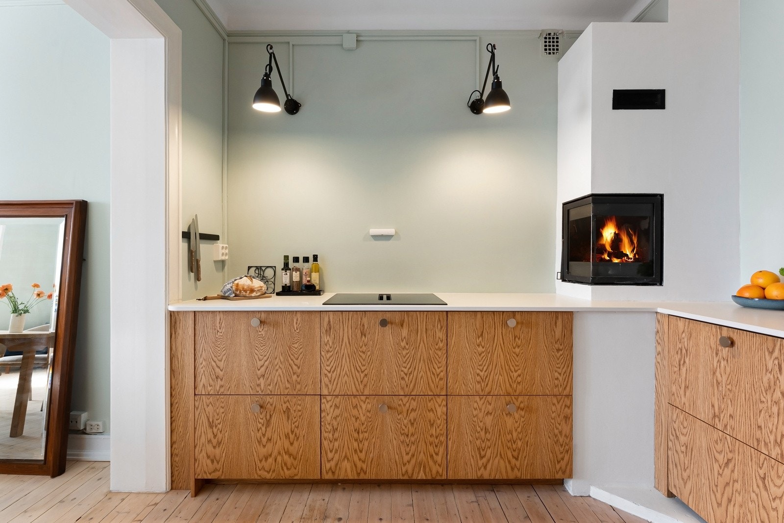 Over benkeplaten er det glatt, malt vegg. Belysningen er løst med designvegglampene fra klassikeren DCW Lampe Gras. Galleribilde