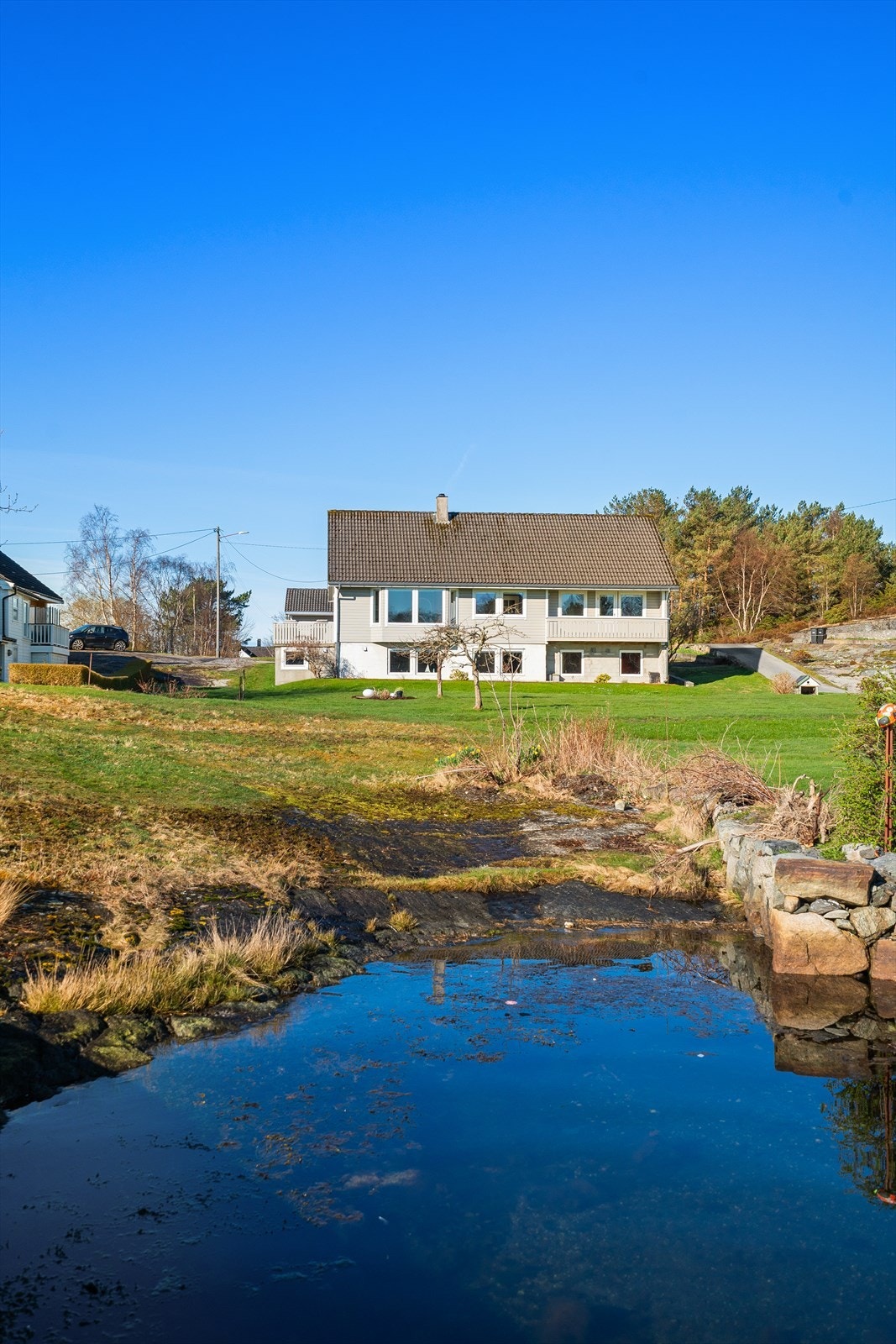 Boligen sett fra sjøsiden, med den store hagen i forgrunnen. Galleribilde