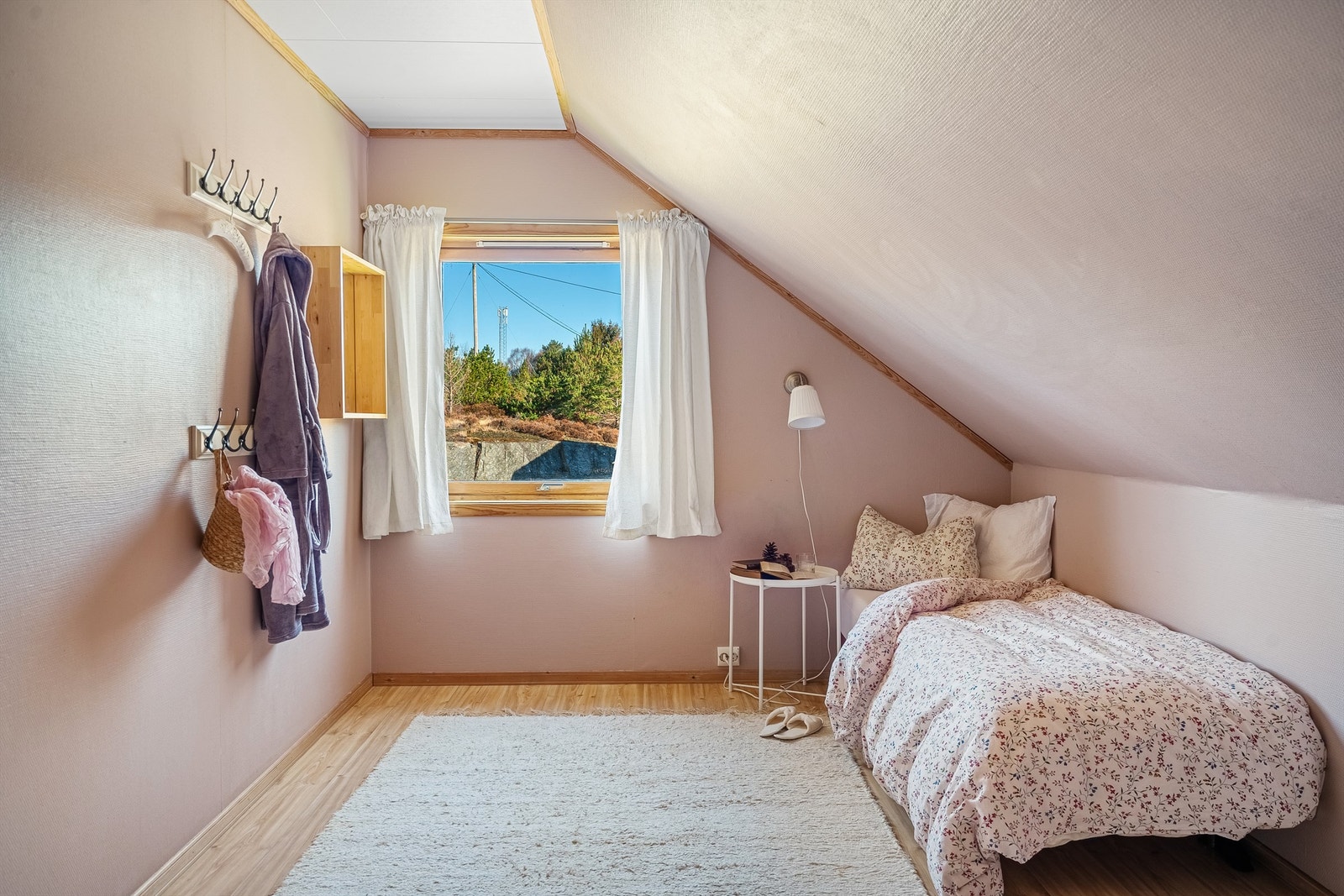 Et annet innredet rom på loftet, med malte, tapetserte vegger og laminatgulv. Galleribilde