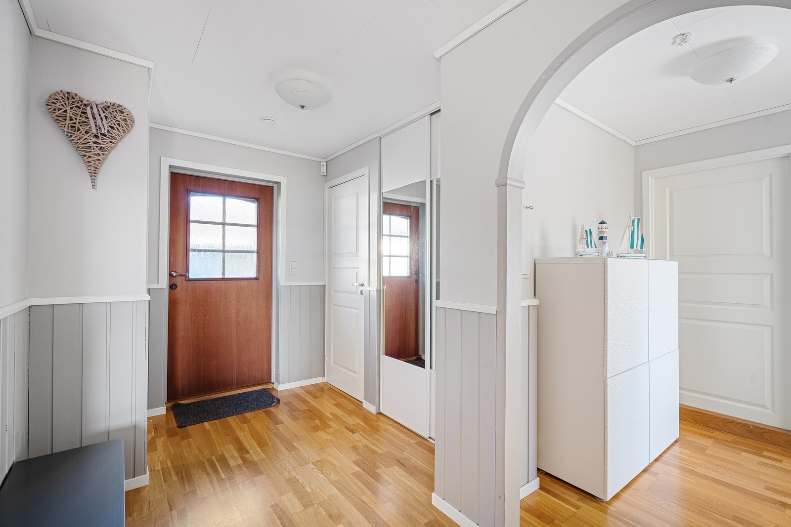 Velkommen inn i en romslig hall i første etasje. Her er det parkett på gulvet og malte panelvegger. Galleribilde