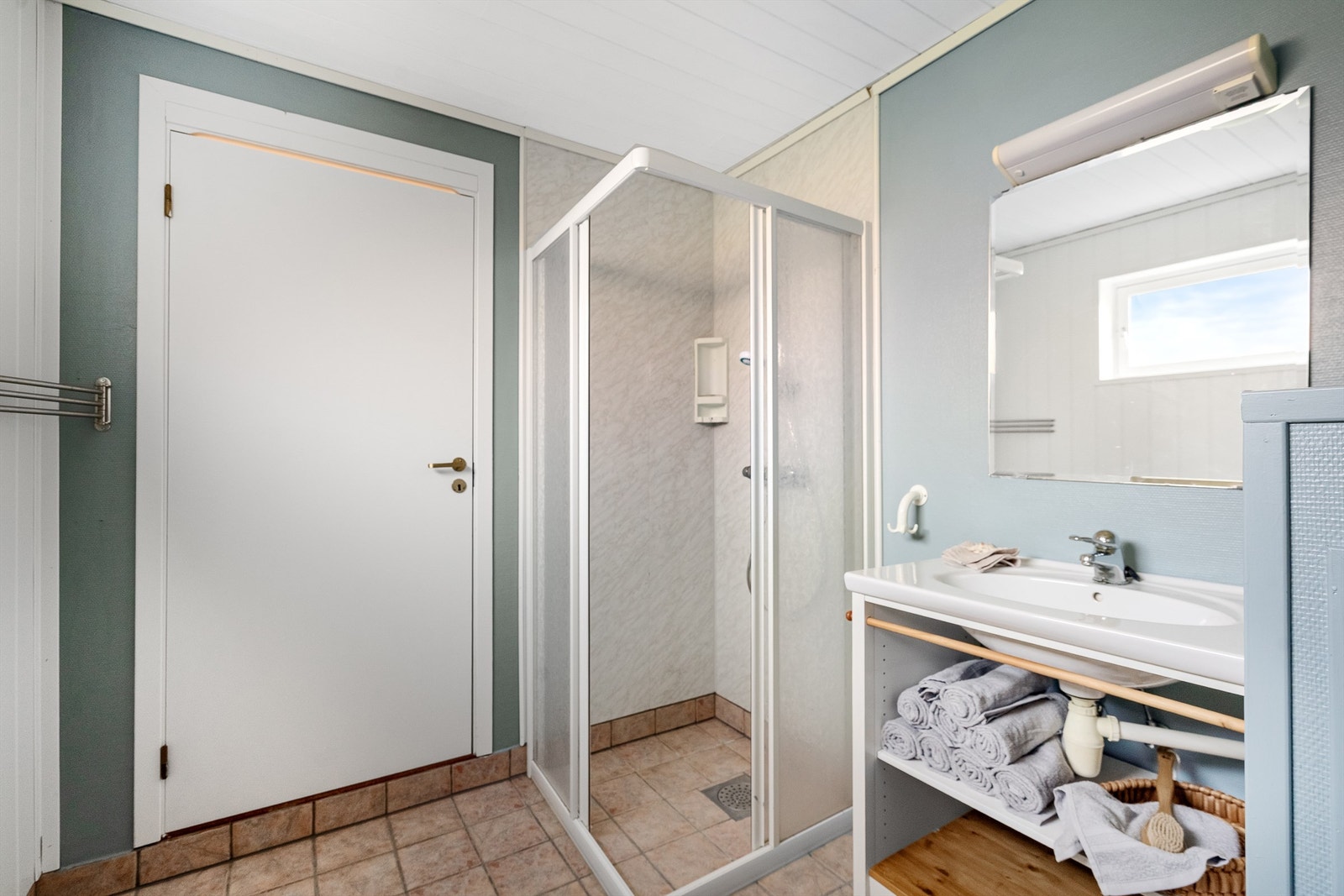 Badet er utstyrt med et praktisk dusjhjørne med dører. Galleribilde