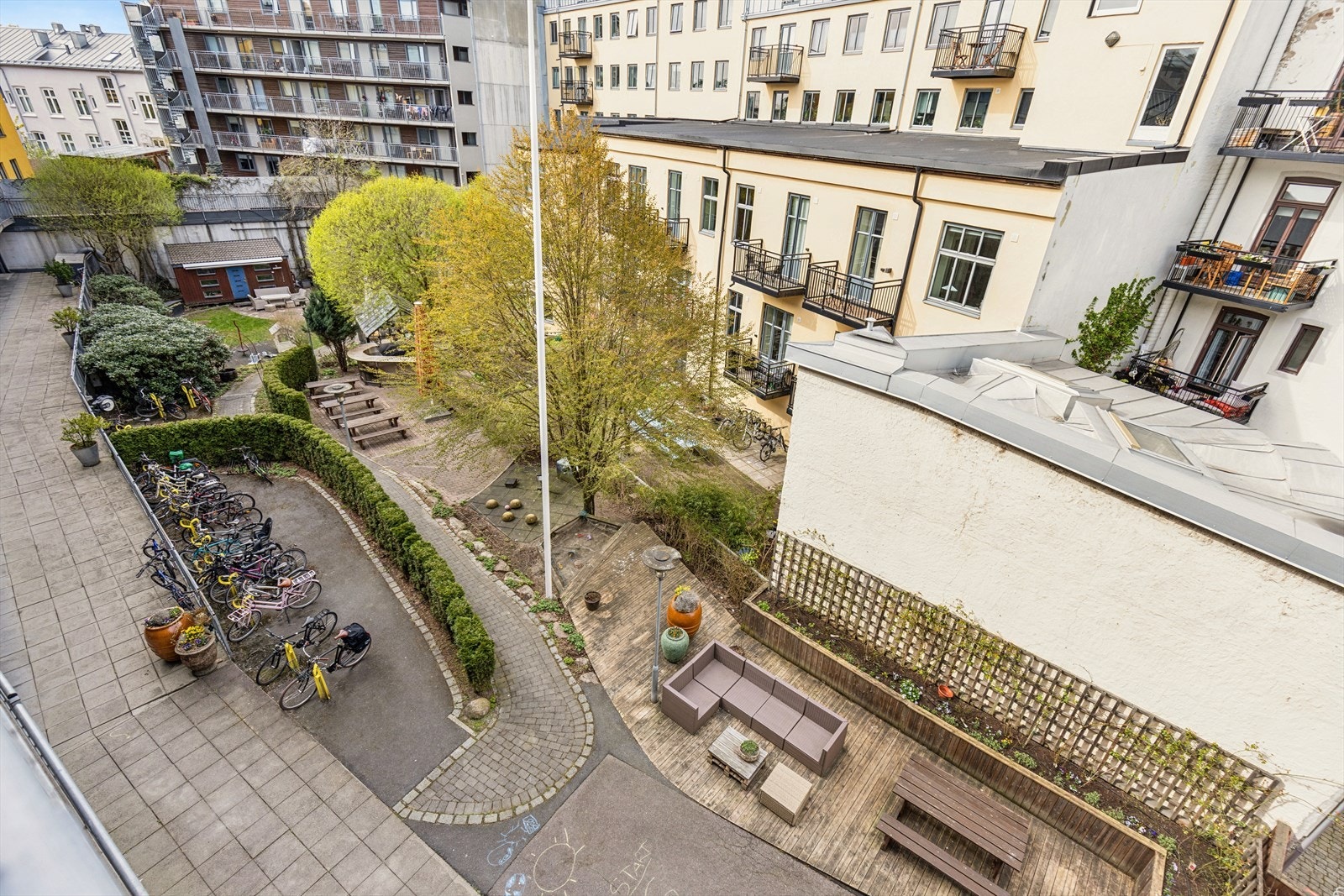 Hyggelige fellesområder med sitteplasser i bakgården. Det er felles utegrill ved sittegruppene. Galleribilde