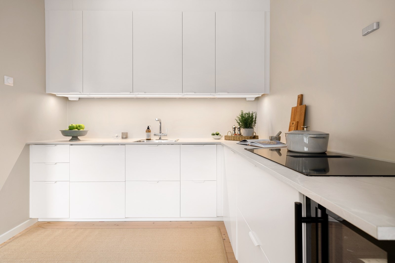Det er godt med skap- og benkeplass, praktisk belysning under overskap og moderne løsninger som induksjonsplatetopp med integrert ventilator. Galleribilde
